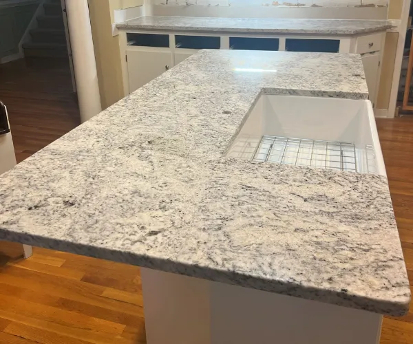 White marble kitchen countertop with built in sink.