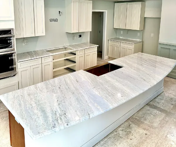 Modern kitchen with large marble countertop island.